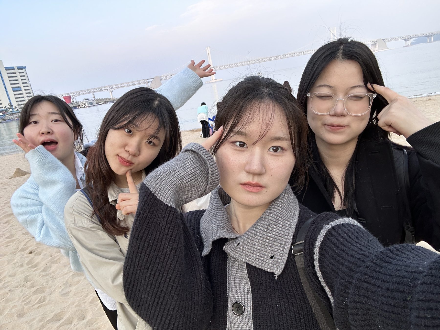 광안대교가 보이는 바닷가에서 찍은 팀원 네 명의 셀카