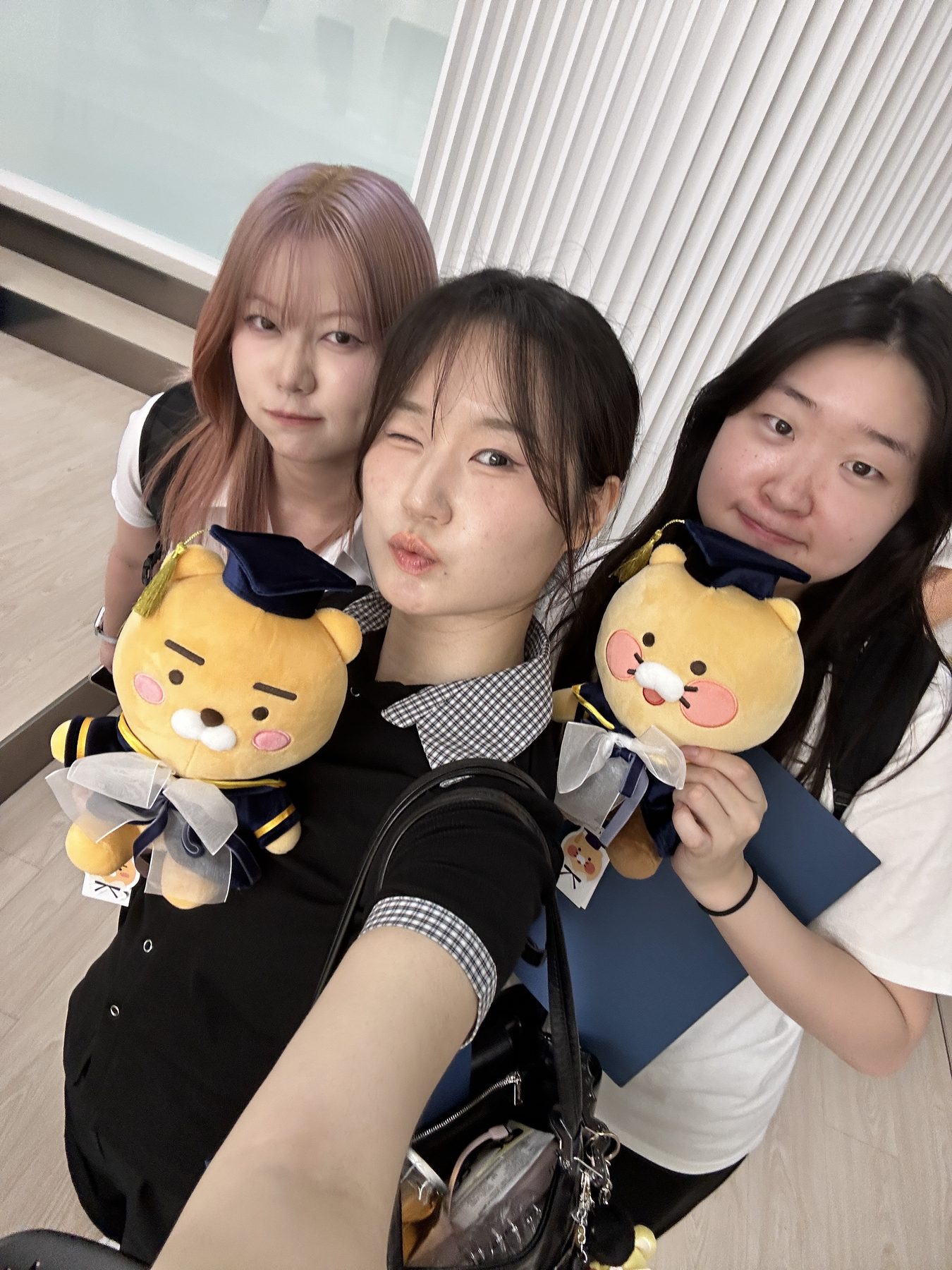 학사모를 쓴 라이언 인형과 상장을 들고 찍은 팀 사진