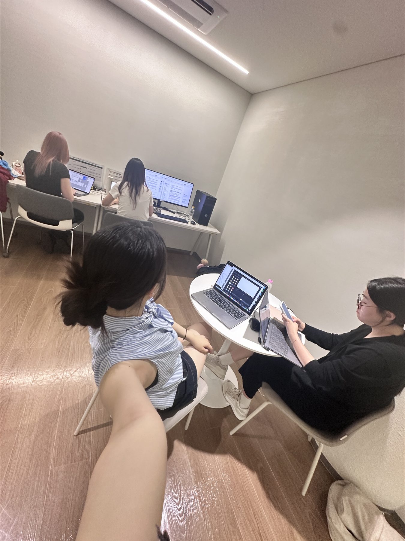 작업실에서 각자 노트북으로 작업 중인 팀원들